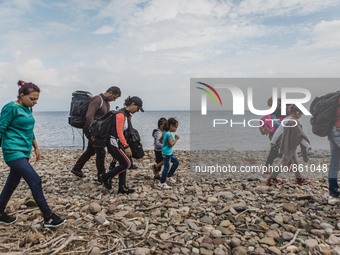 Migrants walk along the beach after they arrive on the Greek island of Lesbos, on September 28, 2015.  (