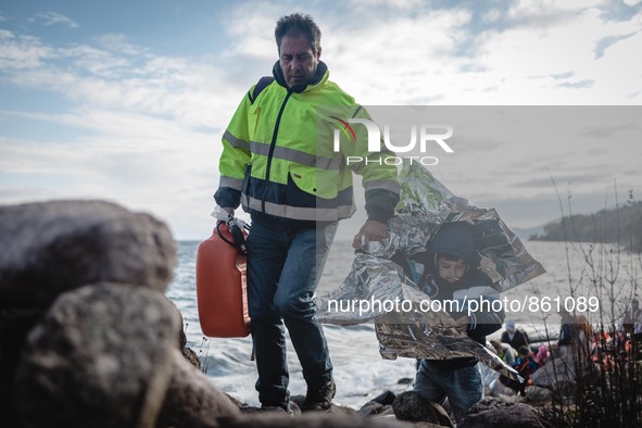 A volunteer helps a child across the rocky shore his boat arrived on in Lesbos, Greece, on September 29, 2015.  