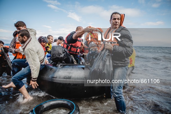 Migrants rush off the dinghy they crossed the sea with once they arrive in Lesbos, Greece, on September 30, 2015.  