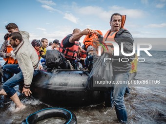 Migrants rush off the dinghy they crossed the sea with once they arrive in Lesbos, Greece, on September 30, 2015.  (