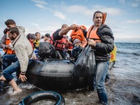 Migrants rush off the dinghy they crossed the sea with once they arrive in Lesbos, Greece, on September 30, 2015.  (