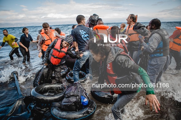 Migrants rush off the dinghy they crossed the sea with once they arrive in Lesbos, Greece, on September 30, 2015.  