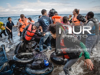 Migrants rush off the dinghy they crossed the sea with once they arrive in Lesbos, Greece, on September 30, 2015.  (