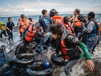 Migrants rush off the dinghy they crossed the sea with once they arrive in Lesbos, Greece, on September 30, 2015.  (