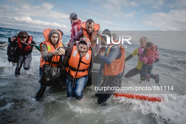 Migrants rush off the dinghy they crossed the sea with once they arrive in Lesbos, Greece, on September 30, 2015.  