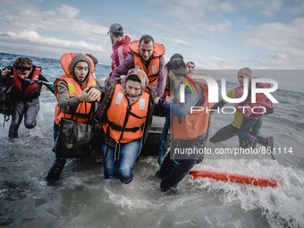 Migrants rush off the dinghy they crossed the sea with once they arrive in Lesbos, Greece, on September 30, 2015.  (