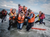 Migrants rush off the dinghy they crossed the sea with once they arrive in Lesbos, Greece, on September 30, 2015.  (