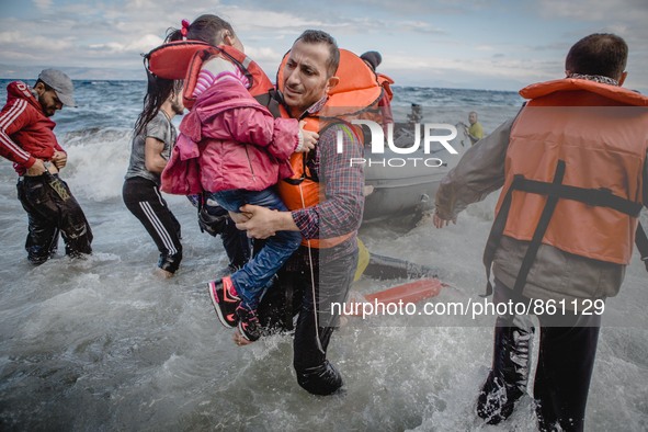 A father carries his daughter off their boat which was stranded in the water for five hours without a motor, in Lesbos, on September 30, 201...