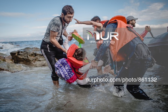 Migrants rush off the dinghy they crossed the sea with once they arrive in Lesbos, Greece, on September 30, 2015.  