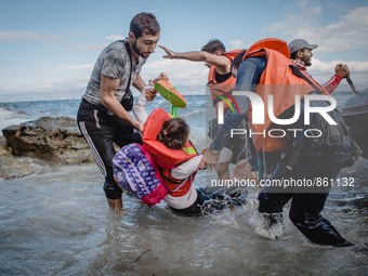 Migrants rush off the dinghy they crossed the sea with once they arrive in Lesbos, Greece, on September 30, 2015.  (