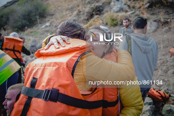 Two women react after arriving on the shore of the Greek island of Lesbos, on September 30, 2015.  