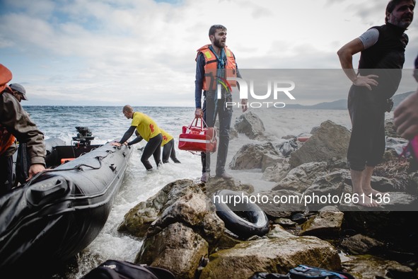 A migrant stands with his lifejacket and personal belongings after arriving on the Greek shore, in Lesbos, on September 30, 2015.  