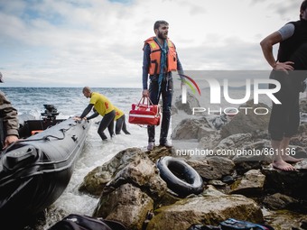 A migrant stands with his lifejacket and personal belongings after arriving on the Greek shore, in Lesbos, on September 30, 2015.  (