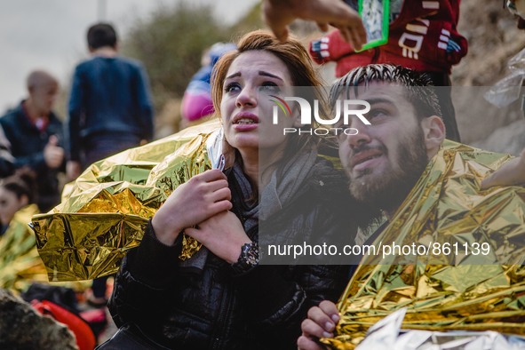 Migrants react after arriving on the shore of the Greek island of Lesbos, on September 30, 2015.  