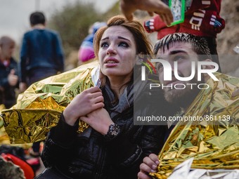 Migrants react after arriving on the shore of the Greek island of Lesbos, on September 30, 2015.  (