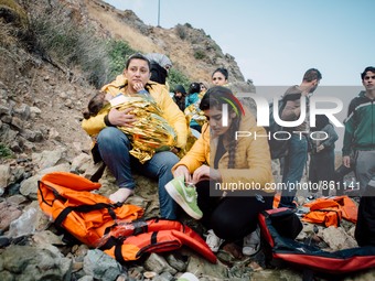 A child wrapped in a thermal blanket rests in her mother’s arms before continuing the journey, on September 30, 2015.  (