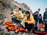 A child wrapped in a thermal blanket rests in her mother’s arms before continuing the journey, on September 30, 2015.  (