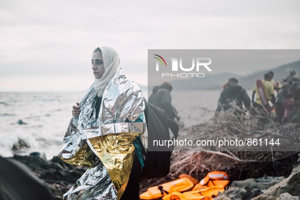 A women wrapped in a thermal blanket looks back at the sea she just crossed from Turkey to Greece, on September 30, 2015.  