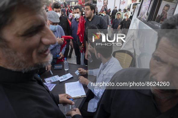 An Iranian health personnel checks documents of a man who wants to receive a dose of the Iranian Noora new coronavirus disease (COVID-19) va...