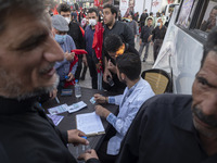 An Iranian health personnel checks documents of a man who wants to receive a dose of the Iranian Noora new coronavirus disease (COVID-19) va...