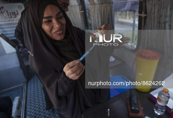 An Iranian female health personnel loads a syringe with the Iranian Noora new coronavirus disease (COVID-19) vaccine at a mobile vaccination...