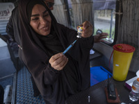 An Iranian female health personnel loads a syringe with the Iranian Noora new coronavirus disease (COVID-19) vaccine at a mobile vaccination...