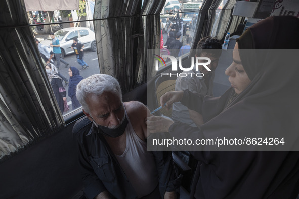 An Iranian man receives a dose of the Iranian Noora new coronavirus disease (COVID-19) vaccine at a mobile vaccination station during a cere...