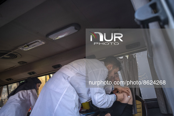 An Iranian man receives a dose of the Iranian Noora new coronavirus disease (COVID-19) vaccine at a mobile vaccination station during a cere...