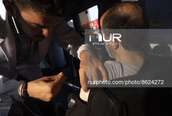 An Iranian man receives a dose of the Iranian Noora new coronavirus disease (COVID-19) vaccine at a mobile vaccination station during a cere...