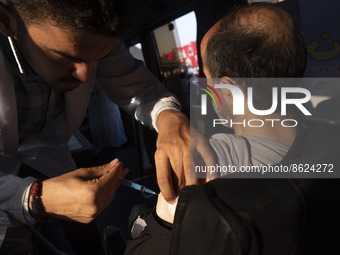 An Iranian man receives a dose of the Iranian Noora new coronavirus disease (COVID-19) vaccine at a mobile vaccination station during a cere...