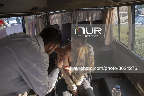 An Iranian man receives a dose of the Iranian Noora new coronavirus disease (COVID-19) vaccine at a mobile vaccination station during a cere...