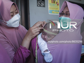 A sleep baby is measured body development by medical officers, during the BIAS (National Child Immunization Month) program at the Integrated...