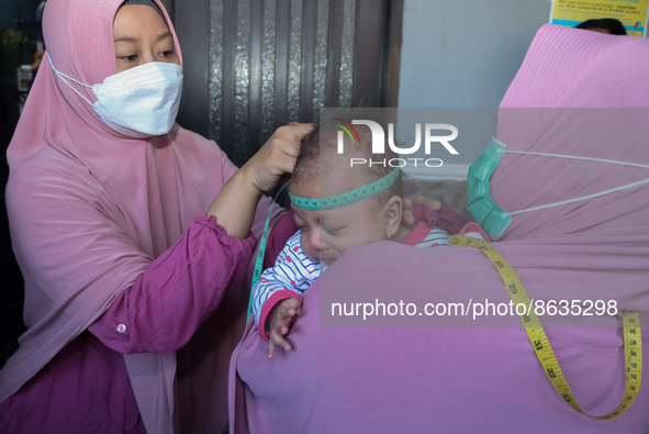 A sleep baby is measured body development by medical officers, during the BIAS (National Child Immunization Month) program at the Integrated...