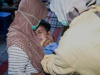 
A crying baby is immunized by a medical officer, during the BIAS (National Child Immunization Month) program at  Integrated Healthcare Cen...