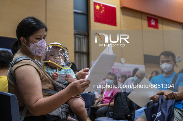 A women holding a baby who is waiting in line to get a jab of the Sinova CoronaVac vaccine made by Sinovac Biotech Ltd. a Chinese biopharmac...