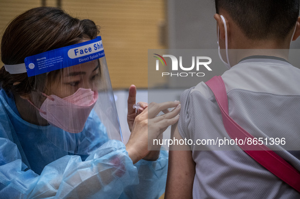 A women wearing a face shield and PPE administering a jab of the Sinova CoronaVac vaccine made by Sinovac Biotech Ltd. a Chinese biopharmace...