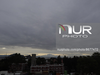 Below, view of the Iztaccihuatl volcano (also known as La Mujer Dormida), during sunrise and cloudy skies in Mexico City due to the monsoon...