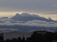 View of the Iztaccihuatl volcano (also known as the Sleeping Woman), during dawn and cloudy skies in Mexico City due to the monsoon that gen...