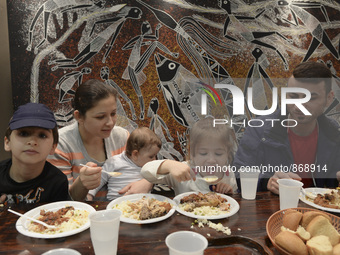 A Syrian family of refugees having a meal in the Aspa Boomerang Restaurant, as the owner Michael Pastrikos, helped by his family members, hi...