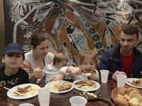 A Syrian family of refugees having a meal in the Aspa Boomerang Restaurant, as the owner Michael Pastrikos, helped by his family members, hi...