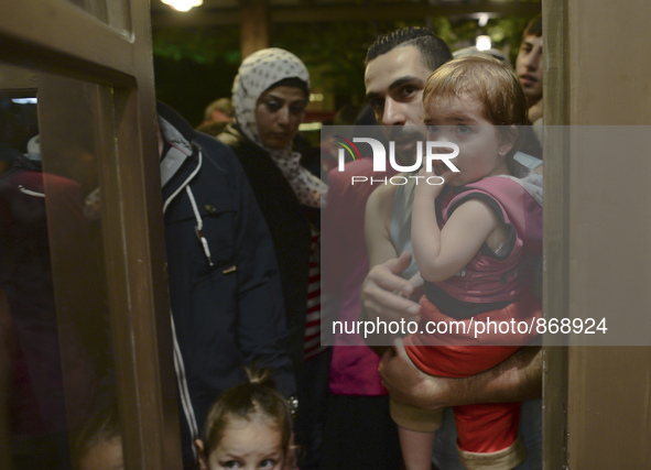 Families of refugees awaiting to enter to the Aspa Boomerang Restaurant, as the owner Michael Pastrikos, helped by his family members, his s...