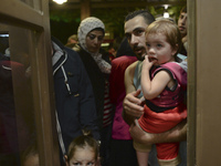 Families of refugees awaiting to enter to the Aspa Boomerang Restaurant, as the owner Michael Pastrikos, helped by his family members, his s...