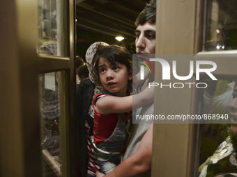 Families of refugees awaiting to enter to the Aspa Boomerang Restaurant, as the owner Michael Pastrikos, helped by his family members, his s...