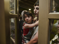 Families of refugees awaiting to enter to the Aspa Boomerang Restaurant, as the owner Michael Pastrikos, helped by his family members, his s...