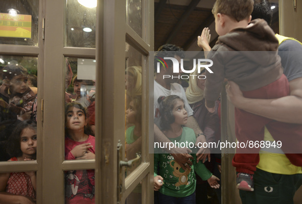 Families of refugees awaiting to enter to the Aspa Boomerang Restaurant, as the owner Michael Pastrikos, helped by his family members, his s...