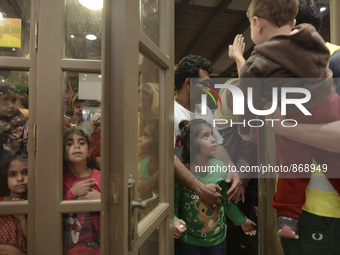 Families of refugees awaiting to enter to the Aspa Boomerang Restaurant, as the owner Michael Pastrikos, helped by his family members, his s...