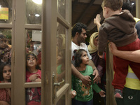 Families of refugees awaiting to enter to the Aspa Boomerang Restaurant, as the owner Michael Pastrikos, helped by his family members, his s...