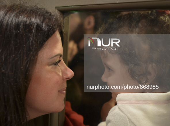 A Canadian volunteer looks from inside of the restaurant at a refugee's child, as many families are awaiting to enter to the Aspa Boomerang...