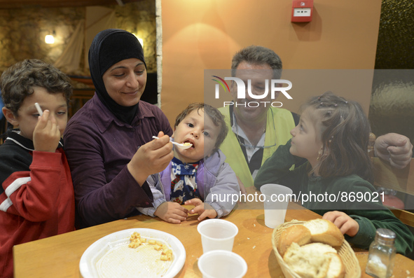 Familiy of refugees from Syria enjoys their Family Evening Meal at the Aspa Boomerang Restaurant, observed by the restaurant owner Michael P...