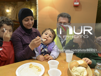 Familiy of refugees from Syria enjoys their Family Evening Meal at the Aspa Boomerang Restaurant, observed by the restaurant owner Michael P...